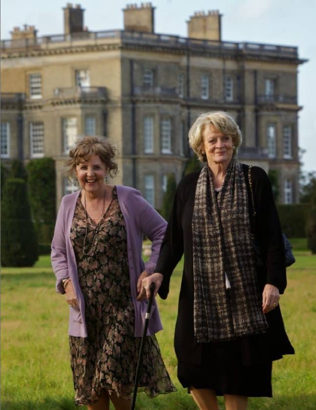 Two ladies smiling at a camera in front of Hedsor House.