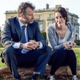Two characters from Fleabag sat on a tree trunk outside Hedsor House.