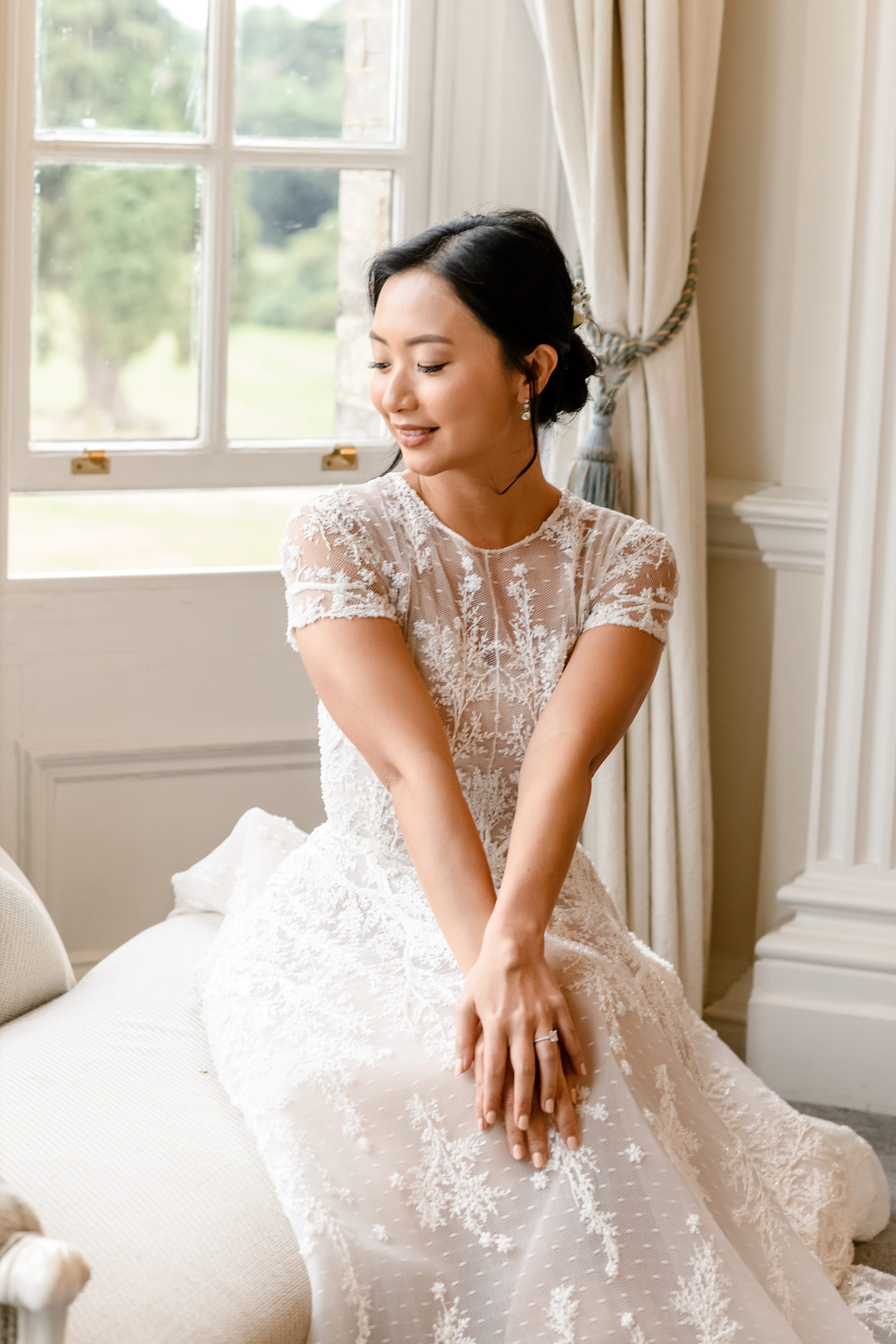 Chinese bride sitting by window at Hedsor House